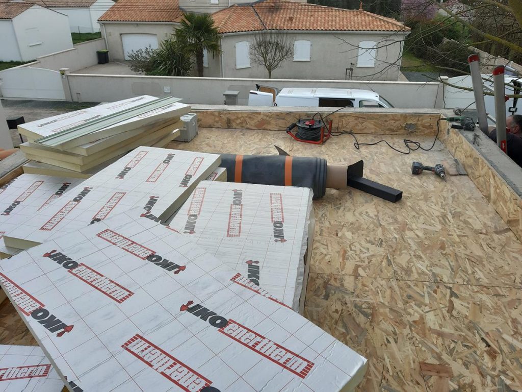 Chantier encollage membrane sur isolant. Support OSB